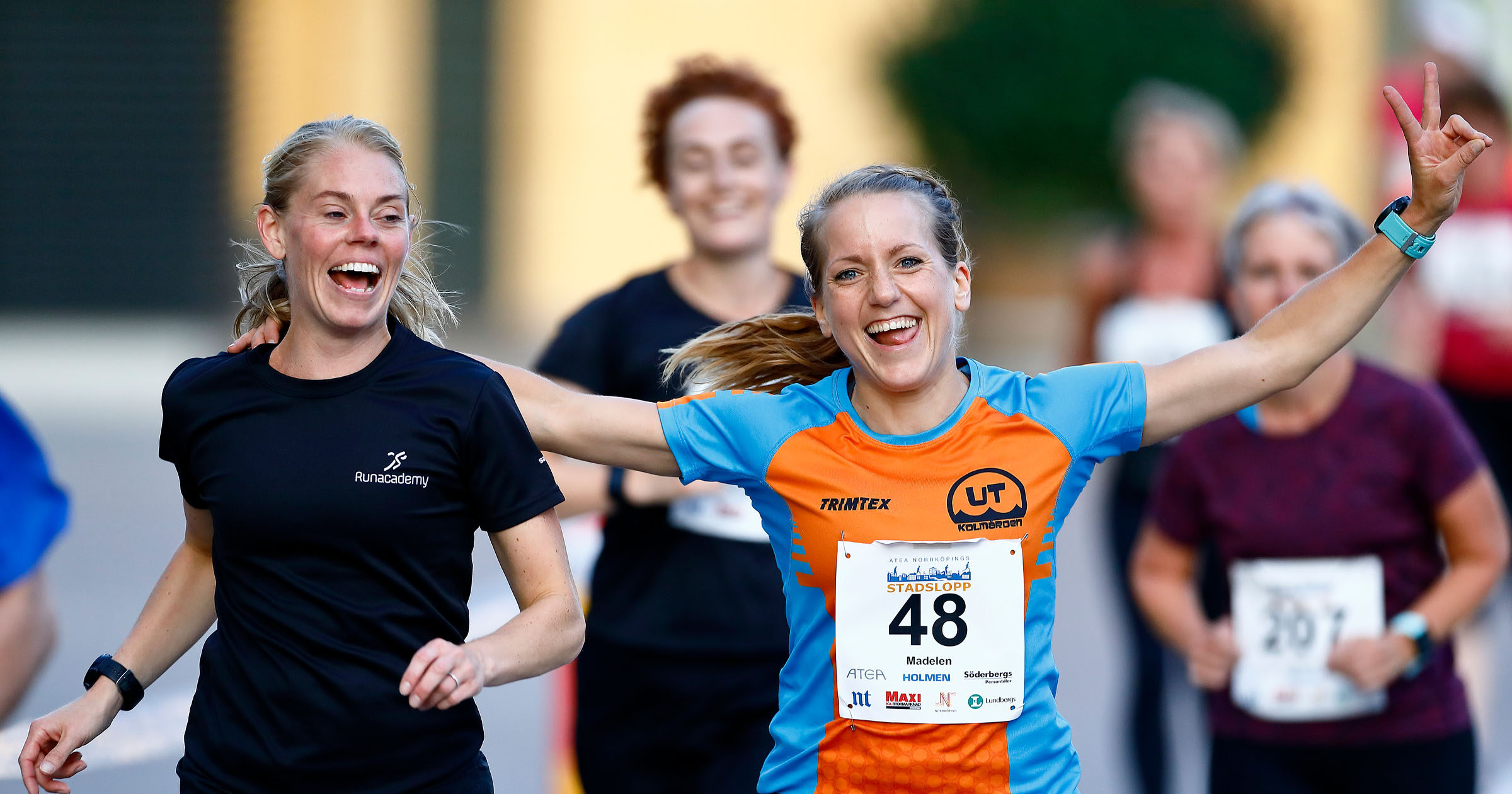 Glada kvinnor springer ett stadslopp och gör segergester